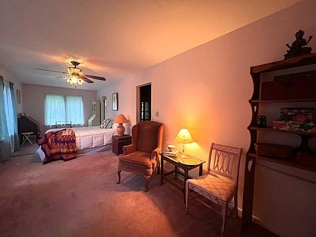 Furnished living room with a sofa, armchairs, carpet, and warm table lamps.