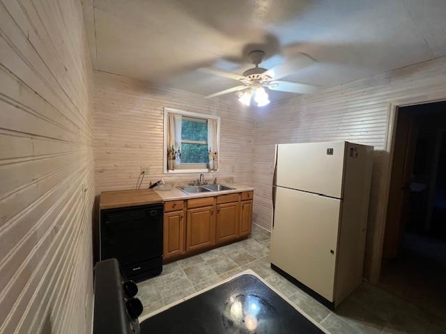 Compact kitchen with light wood cabinets, a black dishwasher, and a white refrigerator.