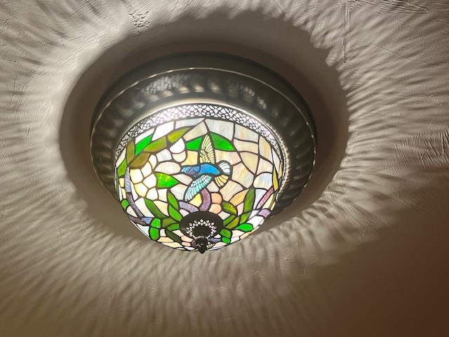 Stained-glass ceiling light with a colorful bird-and-flower design.
