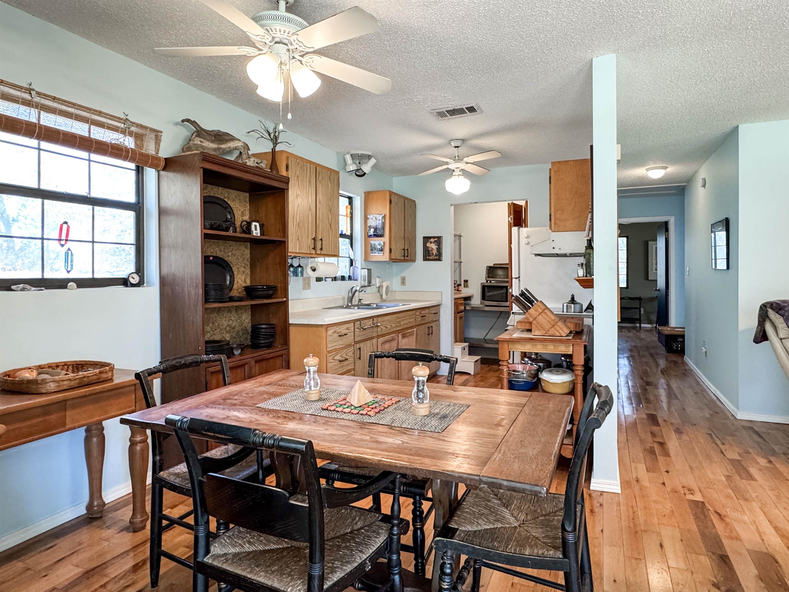Kitchen and dining area with wood cabinets, a large table, and hardwood floors.