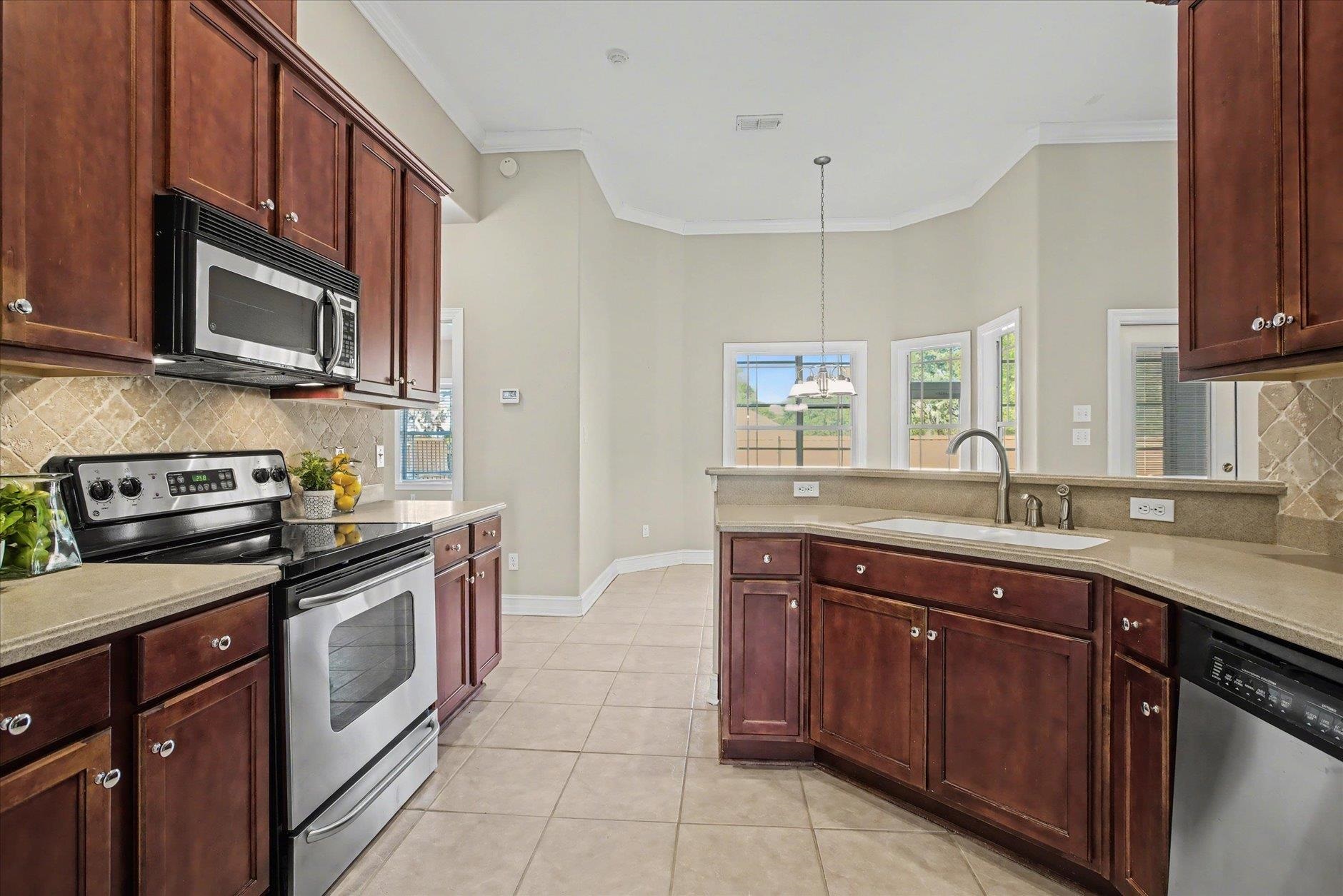 Kitchen with cherry cabinets, stainless steel appliances, and a curved sink peninsula.