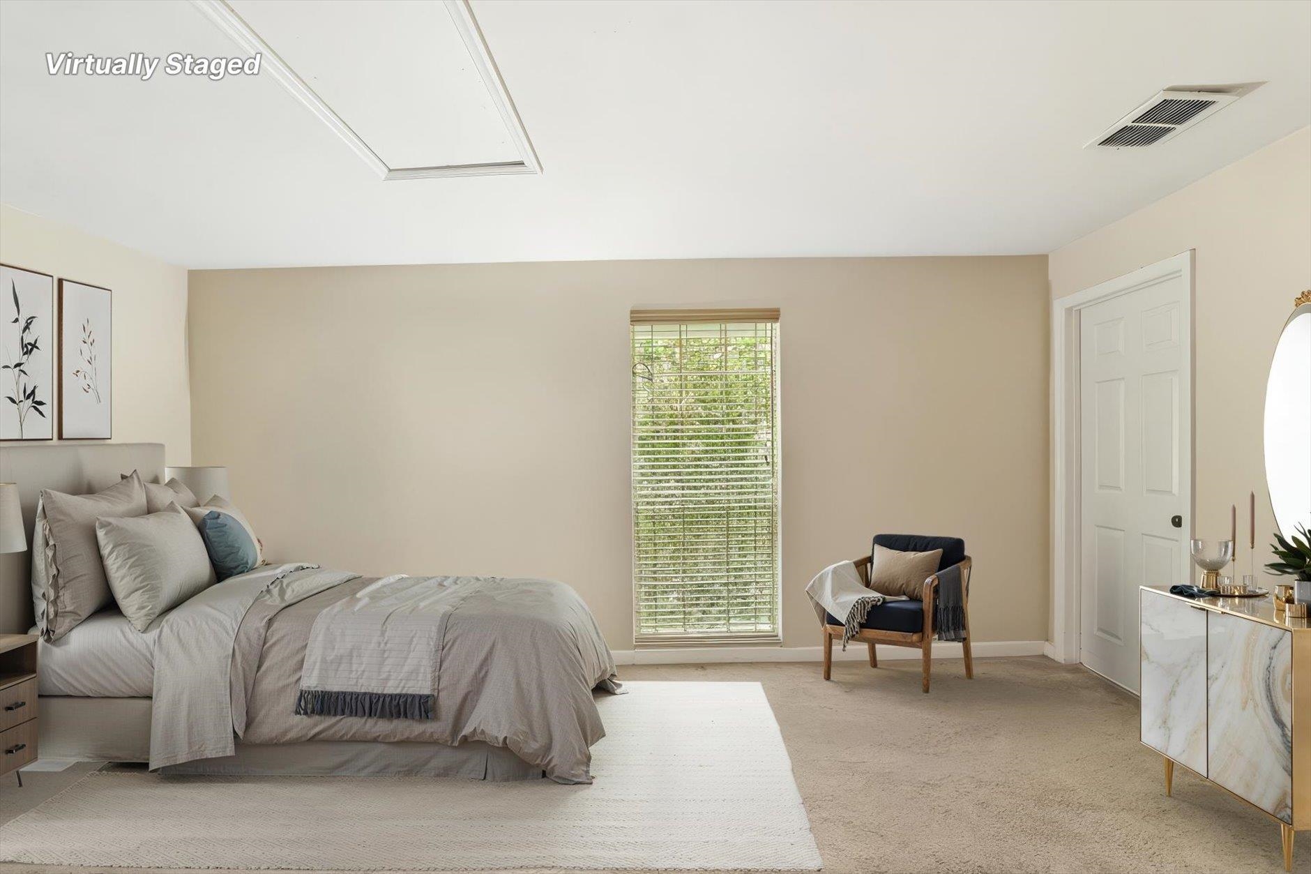Virtually staged bedroom with a gray bed, window blinds, an accent chair, and a marble-look dresser.