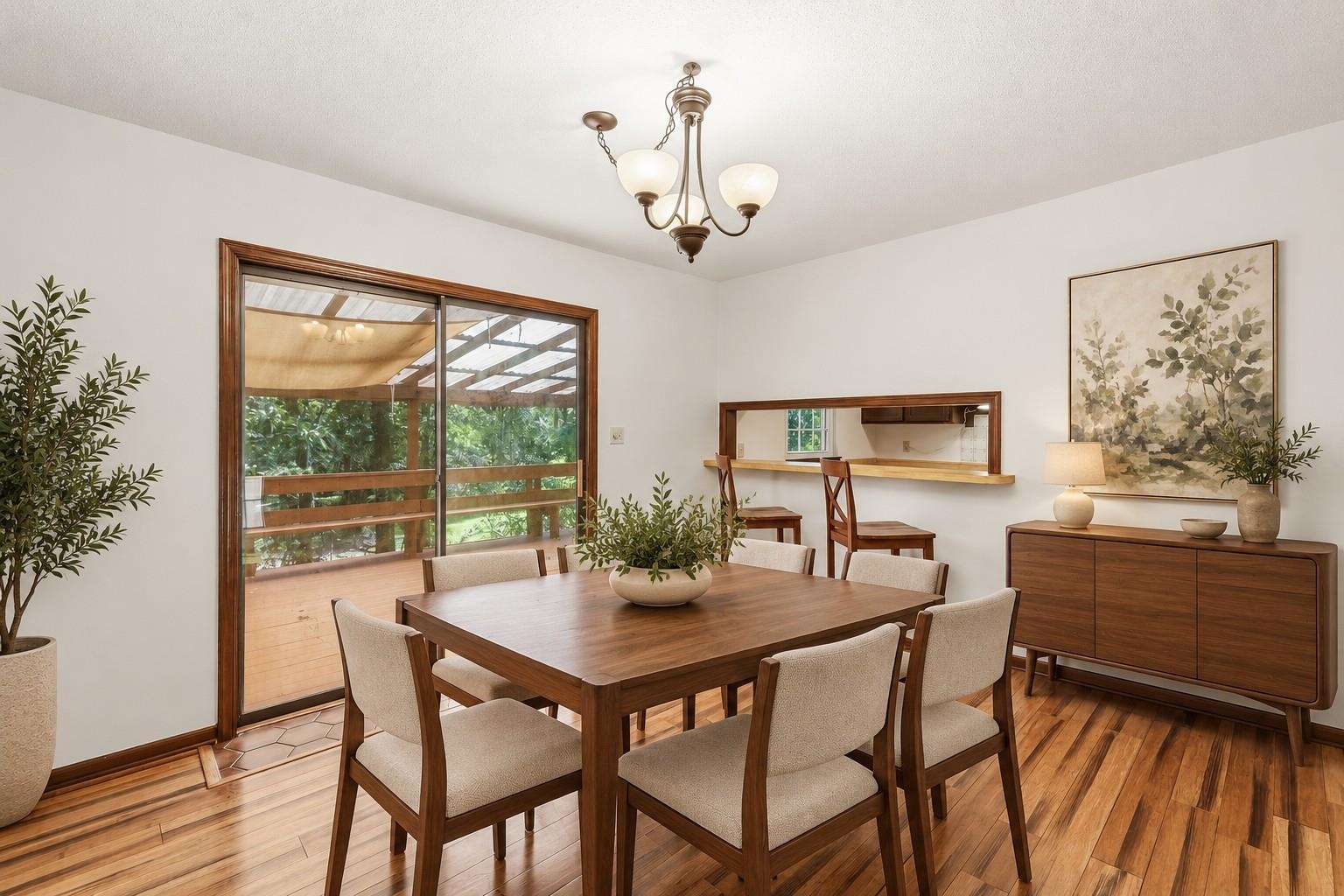 Dining room with a dark wood table, upholstered chairs, and sliding doors to a covered deck.
