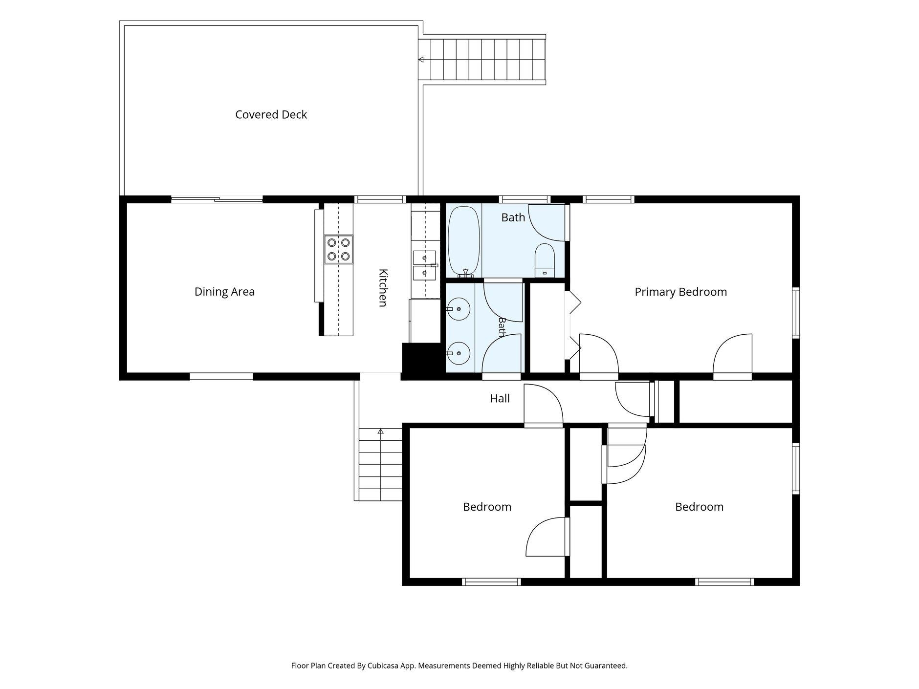 Floor plan showing a covered deck, kitchen, dining area, two bathrooms, and three bedrooms.
