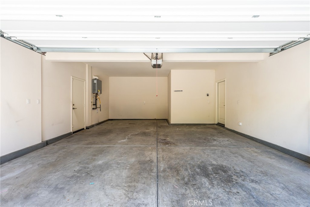 Empty garage with a wide overhead door and concrete floor.