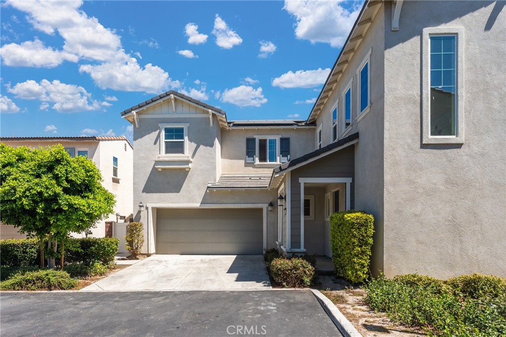 Two-story stucco home with a wide garage driveway and recessed front entry.