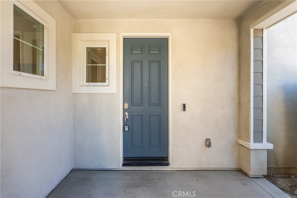 Covered front entry with a blue paneled door and concrete porch.