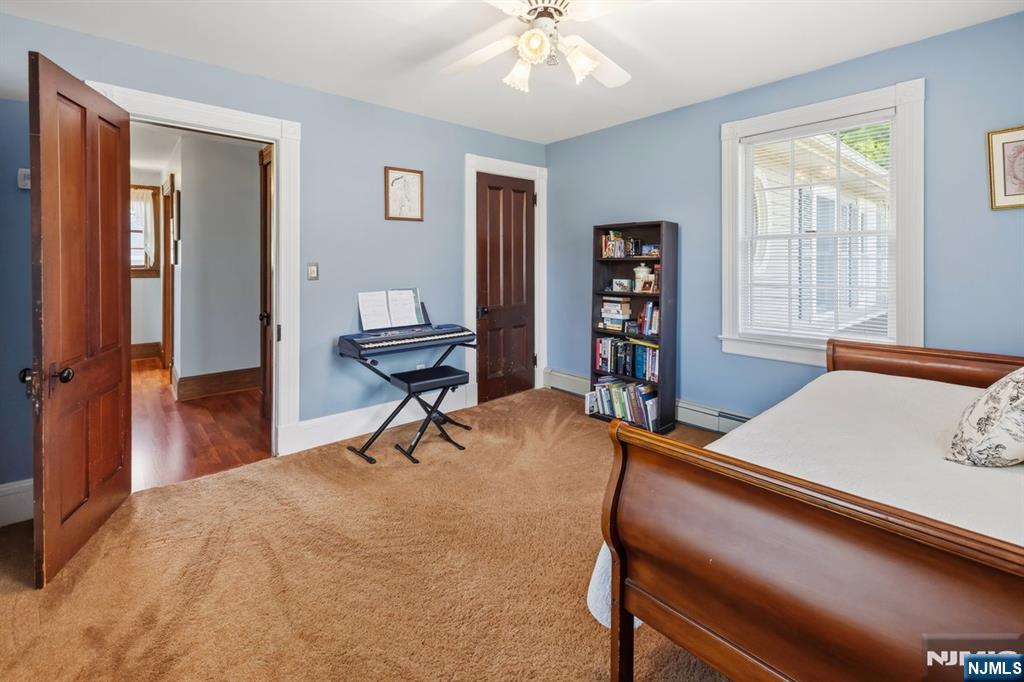 Bedroom with pale blue walls, a wooden bed, and an electronic keyboard beside the doorway.