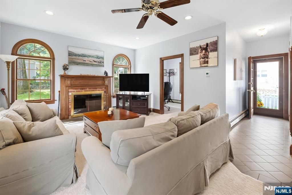 Furnished living room with a fireplace, arched windows, and cream sectional sofas.