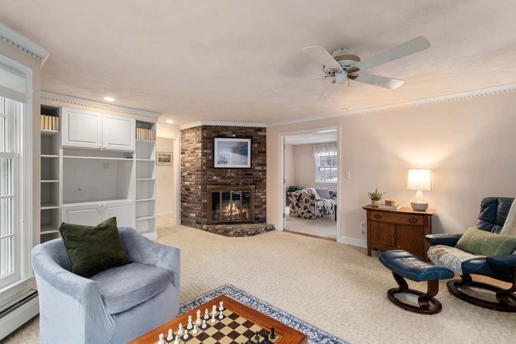 Living room with a brick fireplace, built-in shelving, and a chessboard on the coffee table.