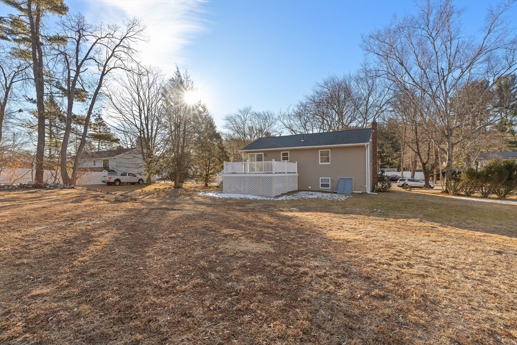 Rear of 33 Meadow Drive with a raised white deck and broad dormant yard.
