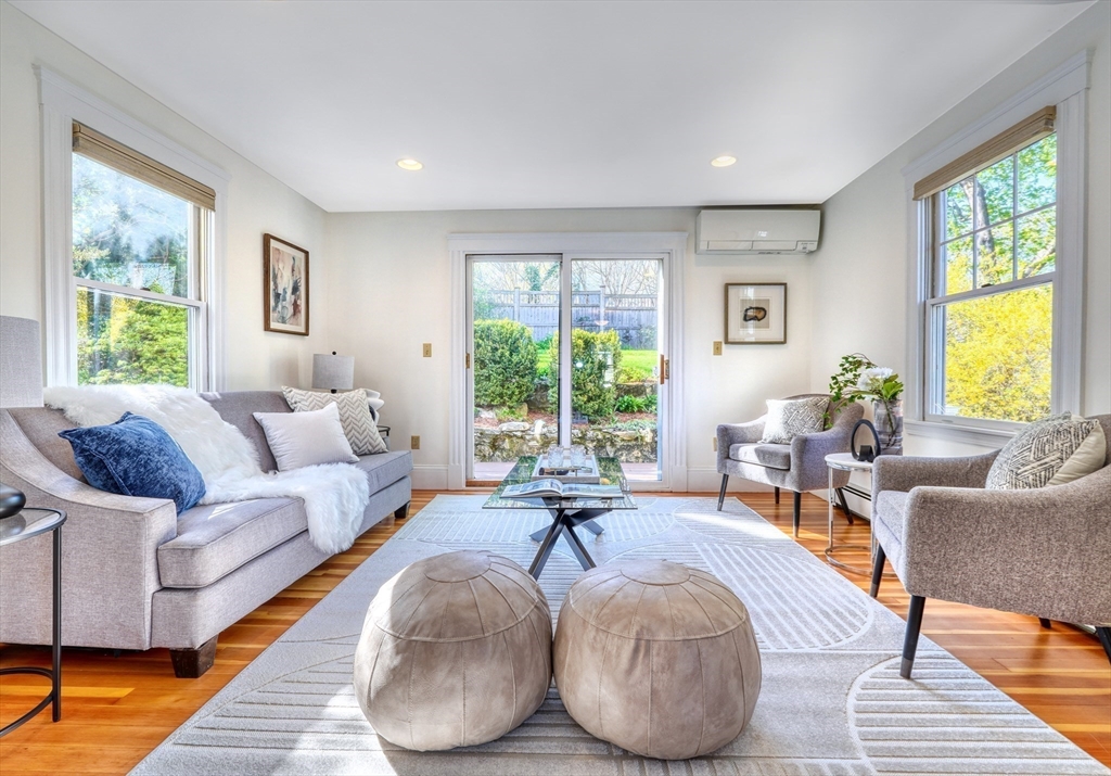 Furnished living room with gray seating, hardwood floors, and sliding doors to the backyard.