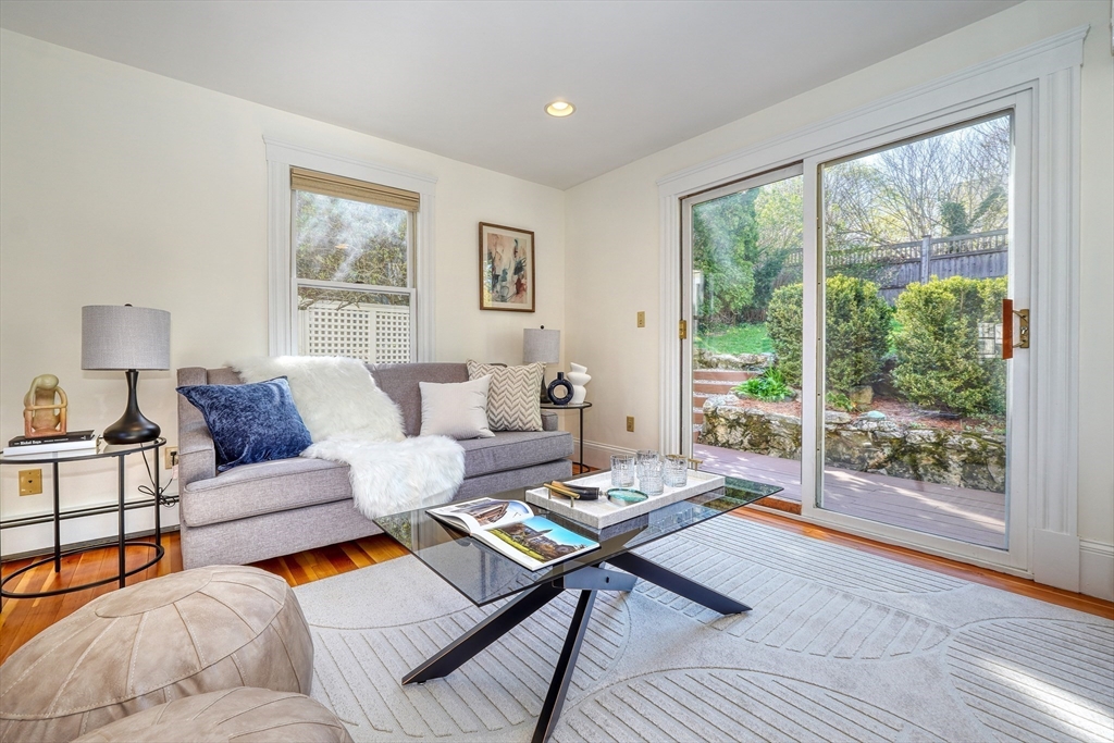 Living room with a gray sofa and glass doors opening to a landscaped patio.