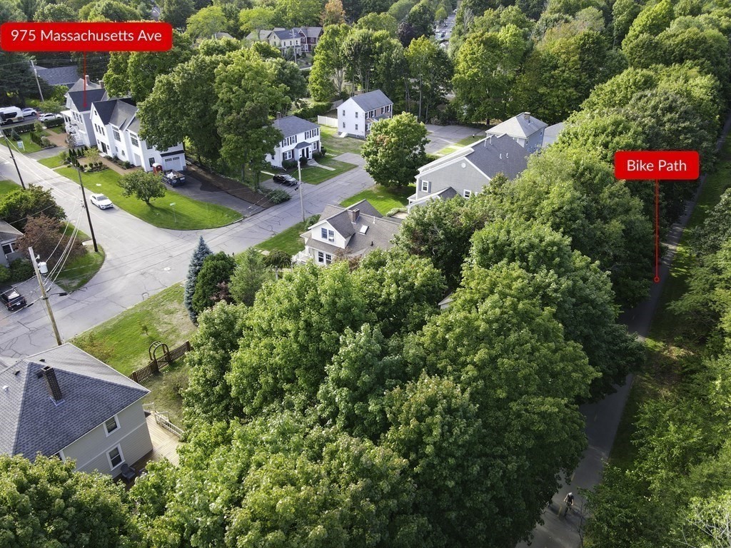 Aerial view of 975 Massachusetts Ave beside a tree-lined bike path and residential street.