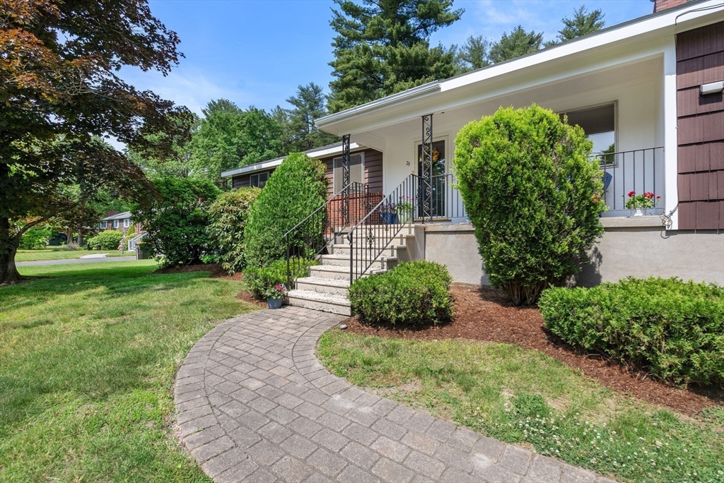 Single-story home with a covered porch, front steps, and a curved walkway through the lawn.