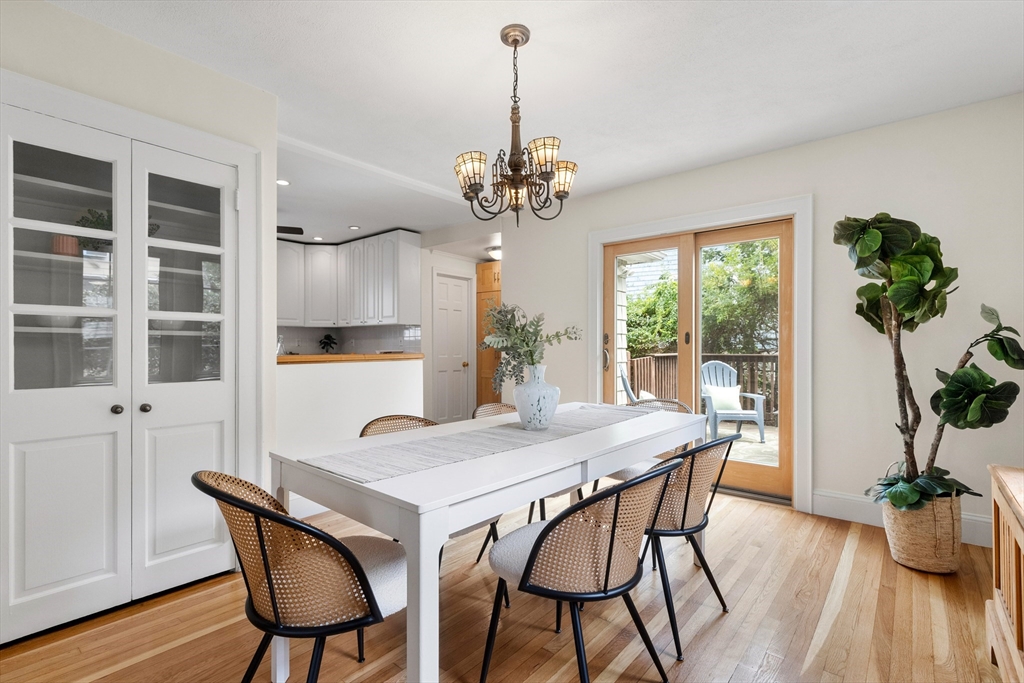 Dining room with a white table, woven chairs, and sliding glass doors to a deck.
