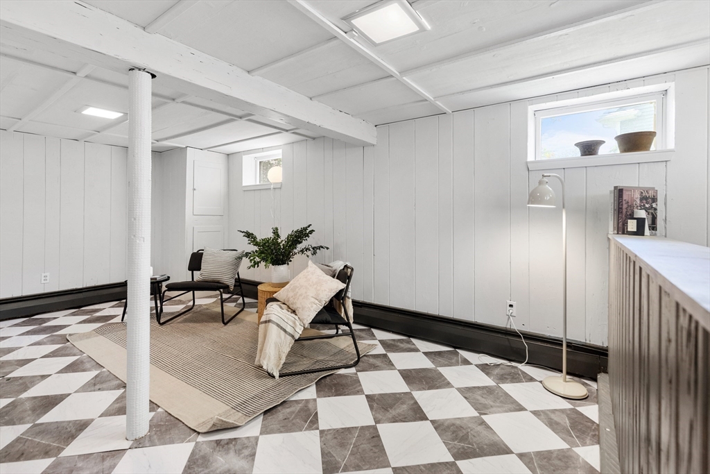 Staged sitting area with two chairs and a rug on checkered tile flooring.