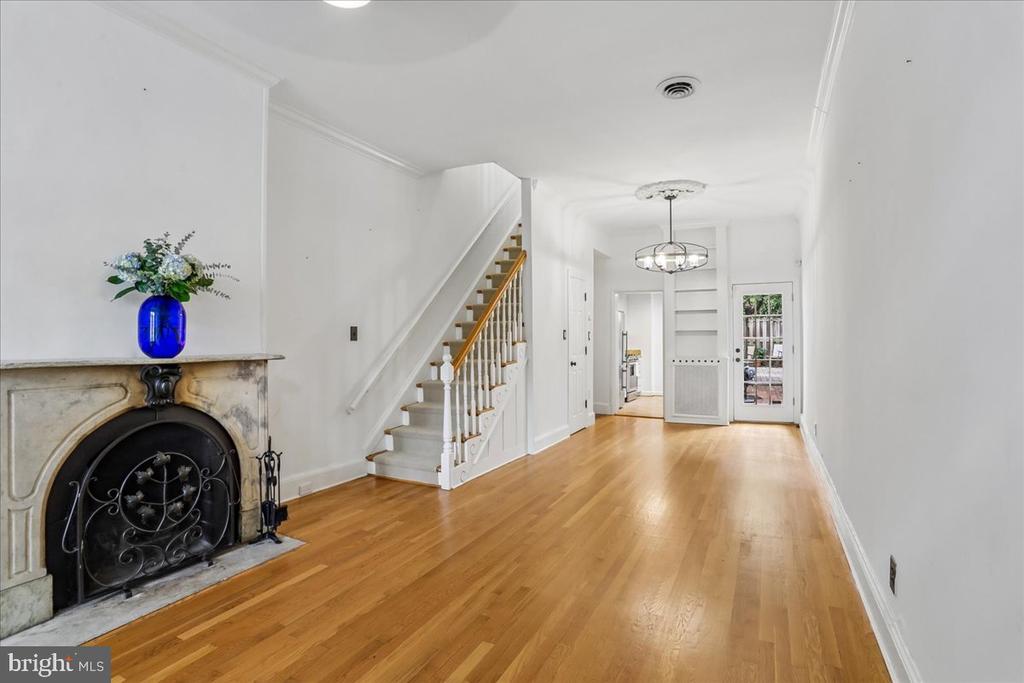 Front room with a marble fireplace, hardwood floors, and a staircase.