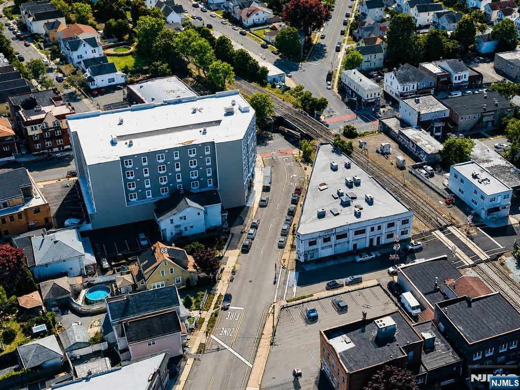 Aerial view of a Bergen County neighborhood with railroad tracks, mixed-use buildings, and tree-lined streets.