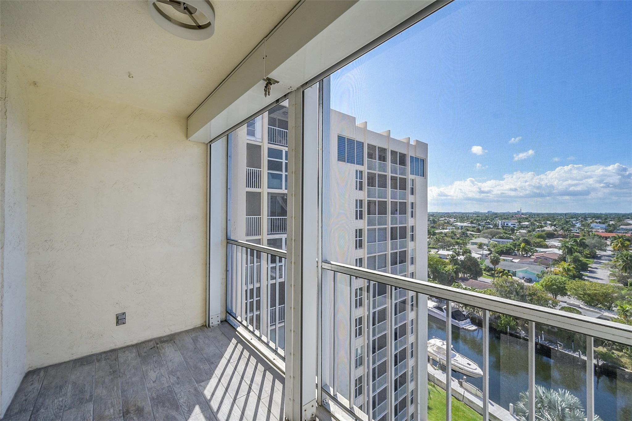 Condo balcony overlooking a canal, boats, and a neighboring high-rise.
