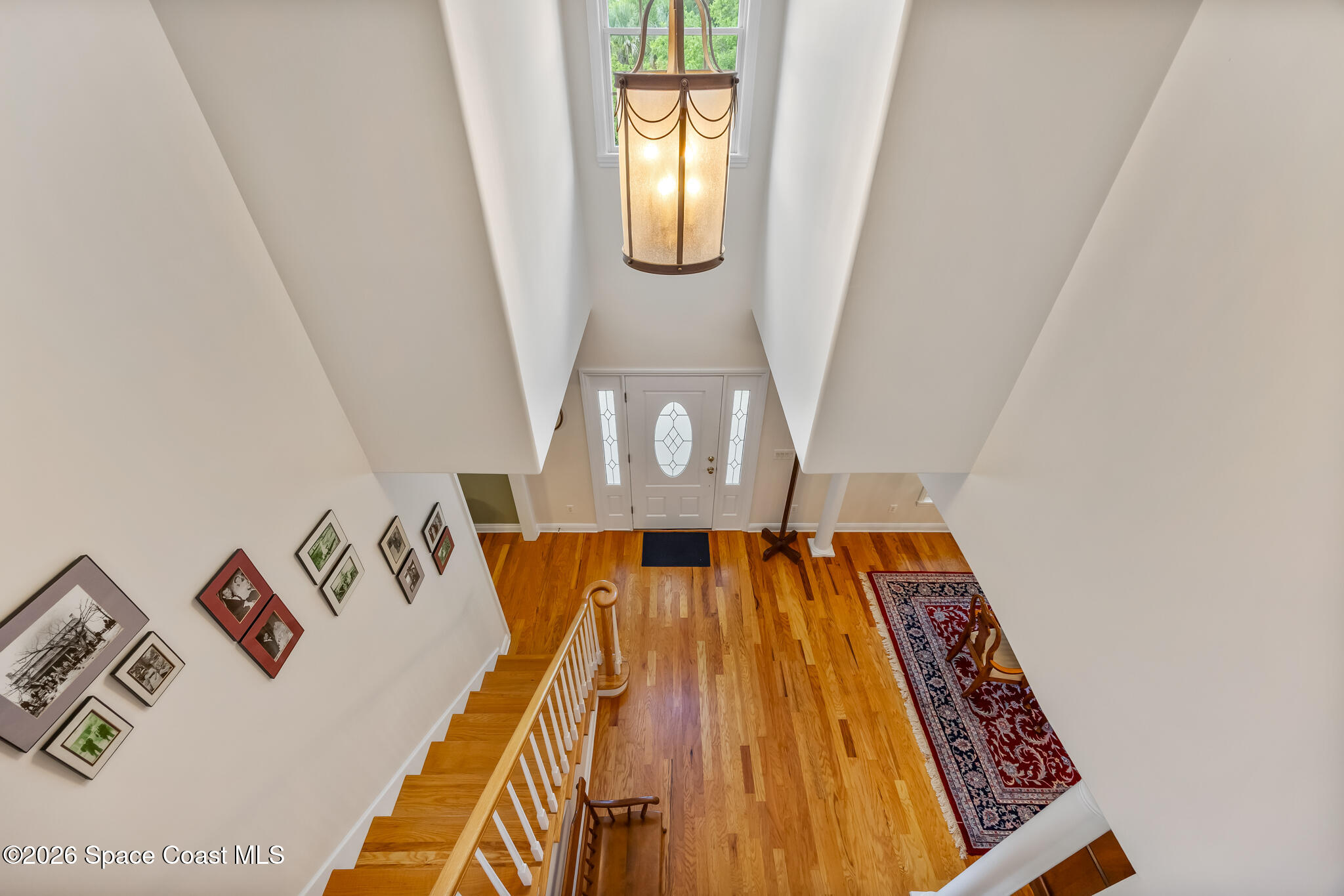 Two-story foyer with hardwood floors, a staircase, and a hanging lantern above the entry.