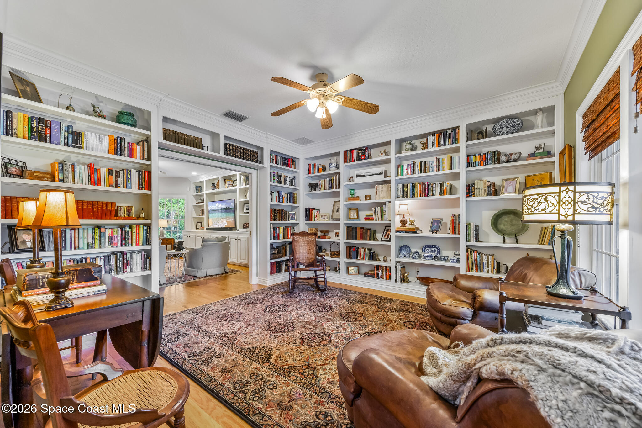 Library with built-in bookshelves, leather seating, and a patterned area rug.