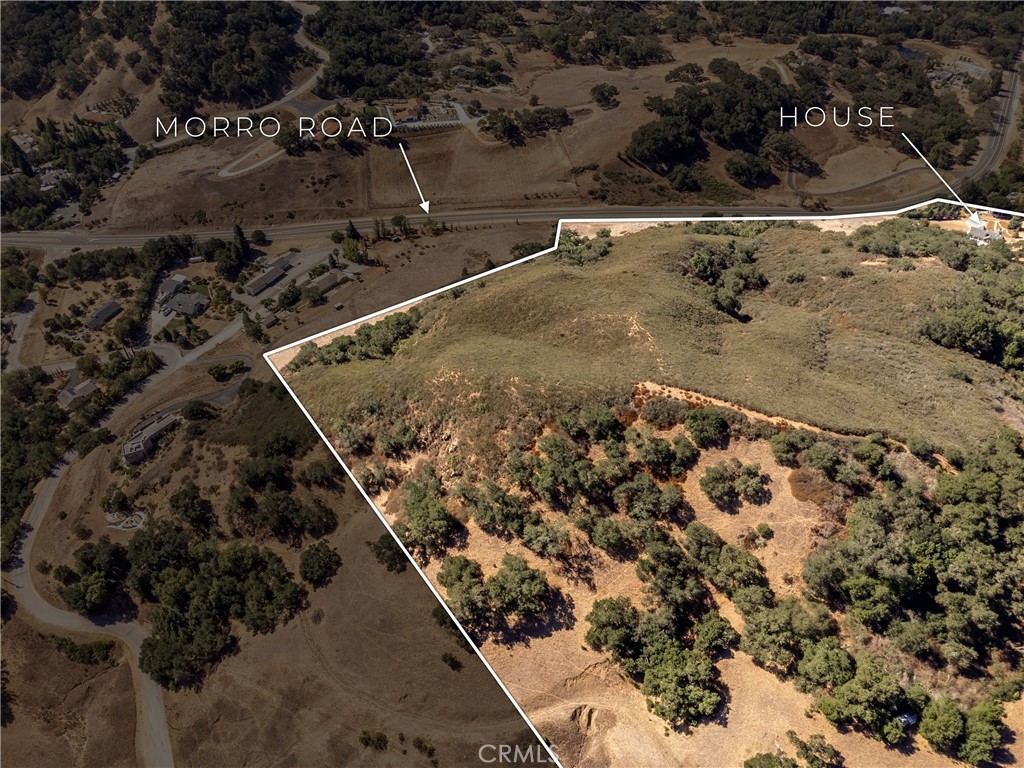 Outlined hillside property beside Morro Road, with a house near the far boundary.