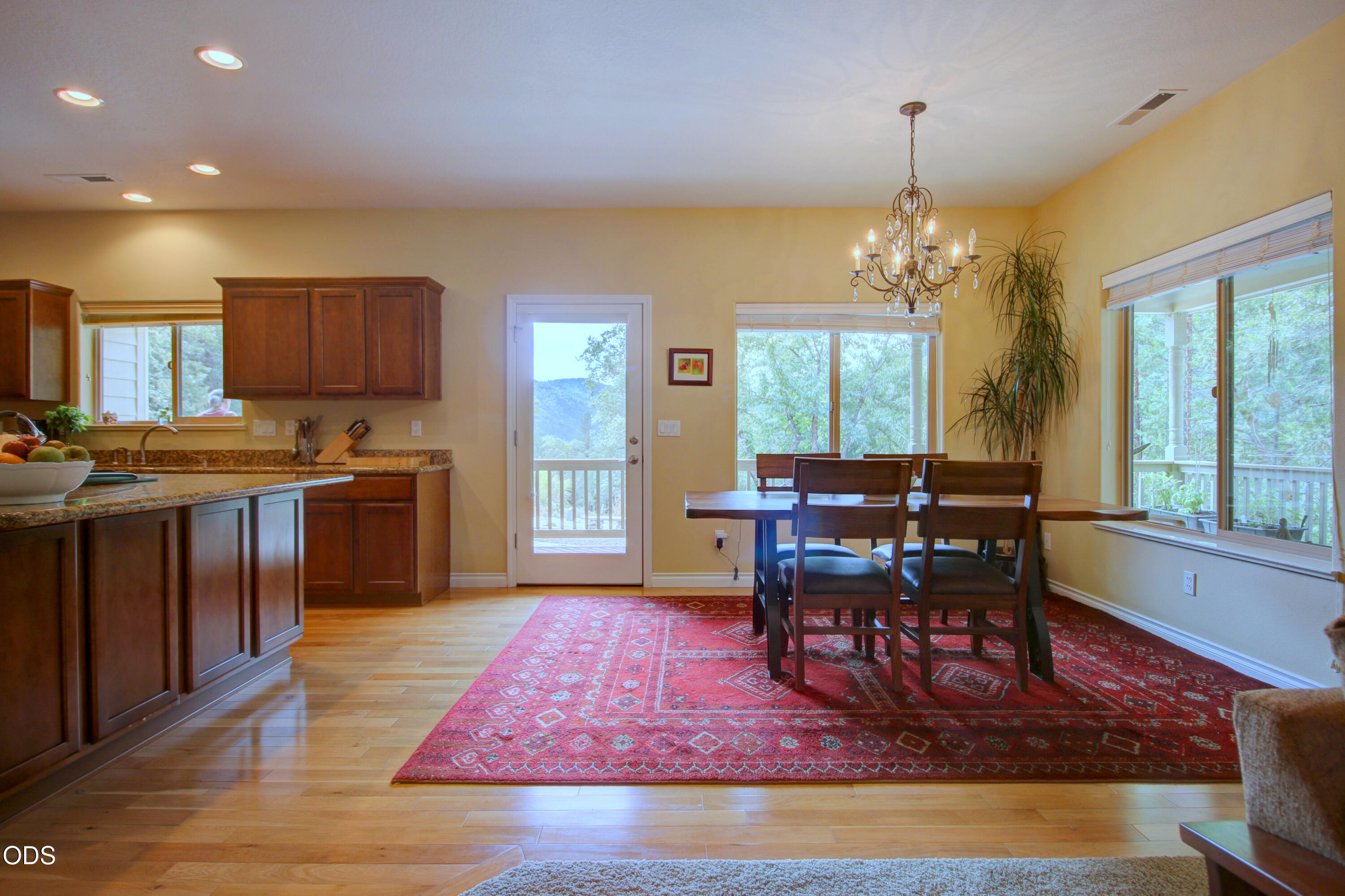 Kitchen and dining area with dark wood cabinets, a chandelier, and mountain views through large windows.