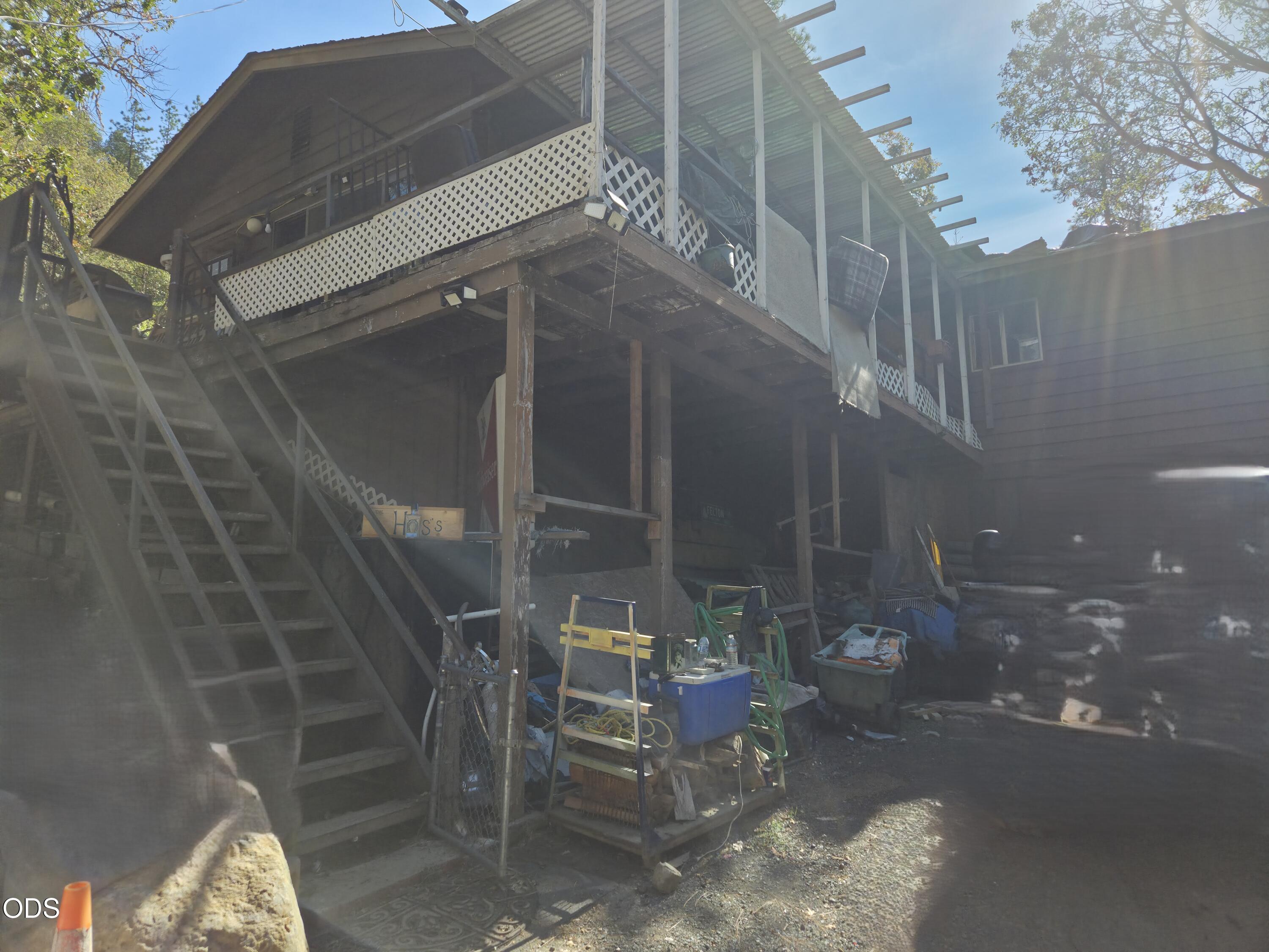 House exterior with a large elevated deck, white lattice railing, and stairs.