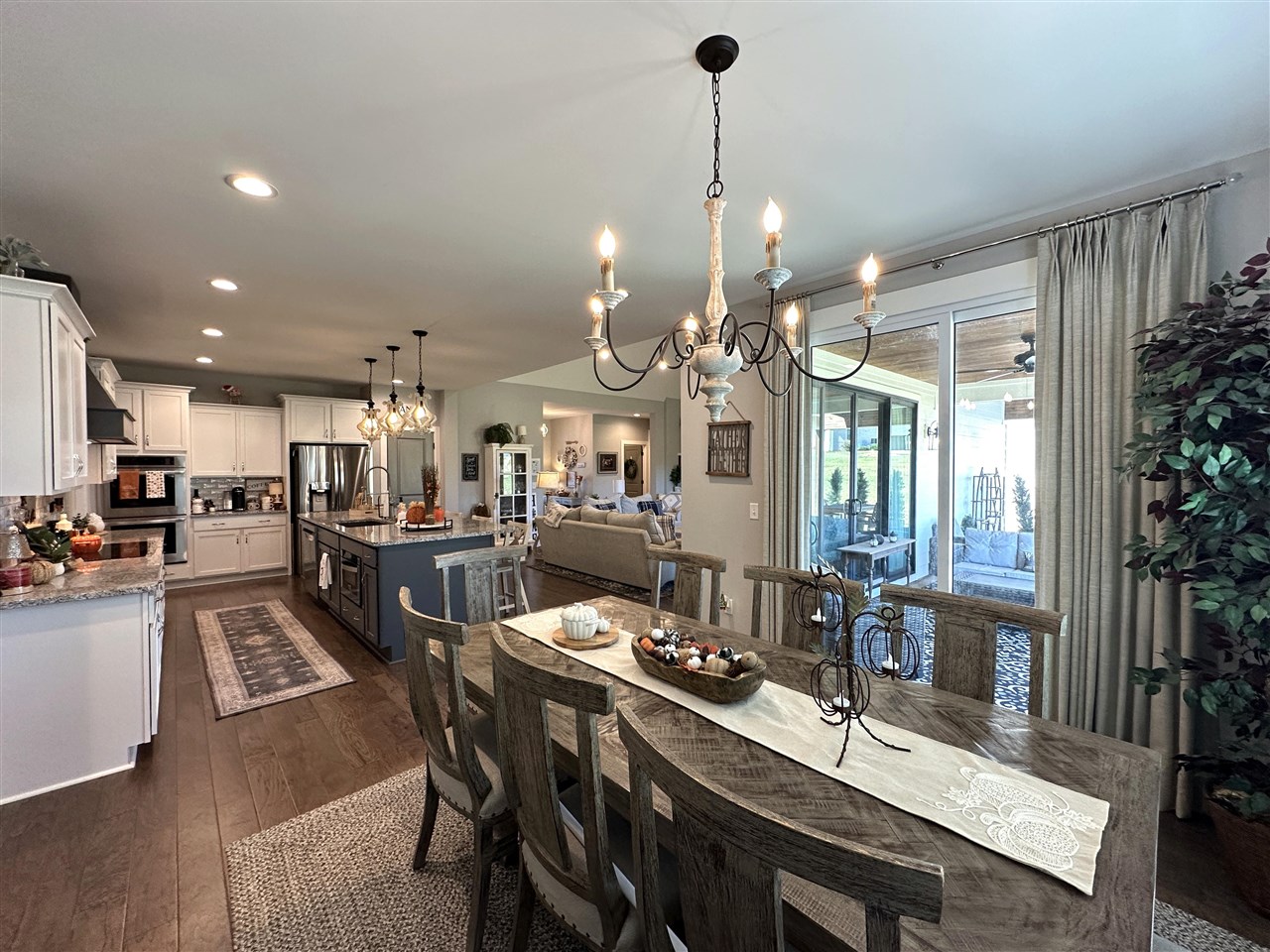 Open-plan kitchen and dining area with a blue island and sliding doors to a covered patio.