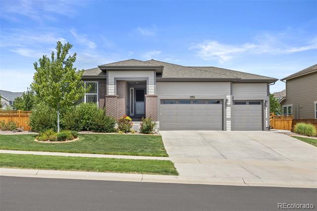 Single-story home with brick accents, a two-car garage, and a wide concrete driveway.