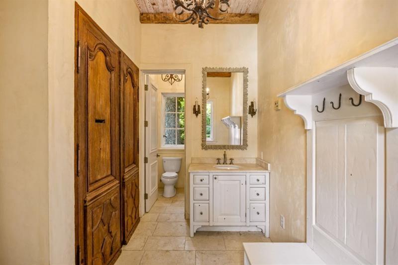 Bathroom vanity area with ornate wooden cabinetry, a white built-in bench, and an adjoining toilet.