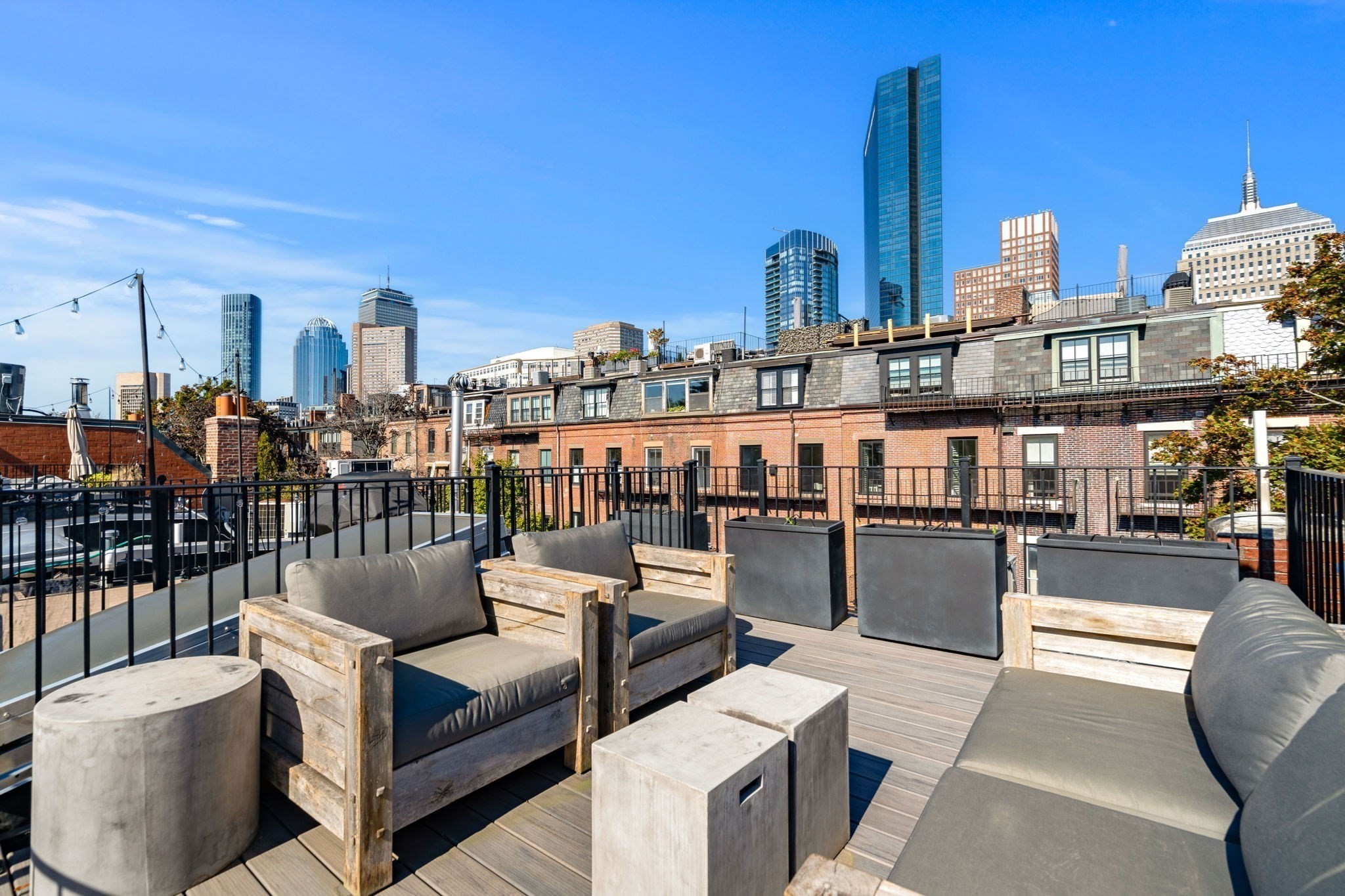 Furnished rooftop terrace with lounge seating and views of the Boston skyline.
