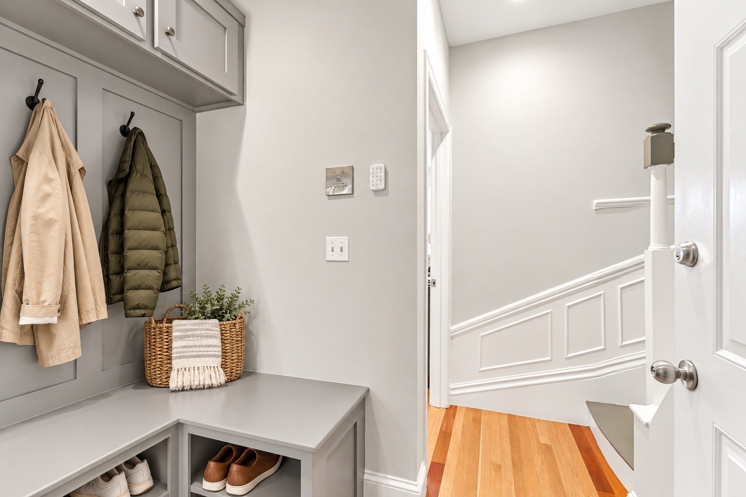 Entryway mudroom with built-in cabinets, coat hooks, shoe storage, and a doorway to the stair hall.
