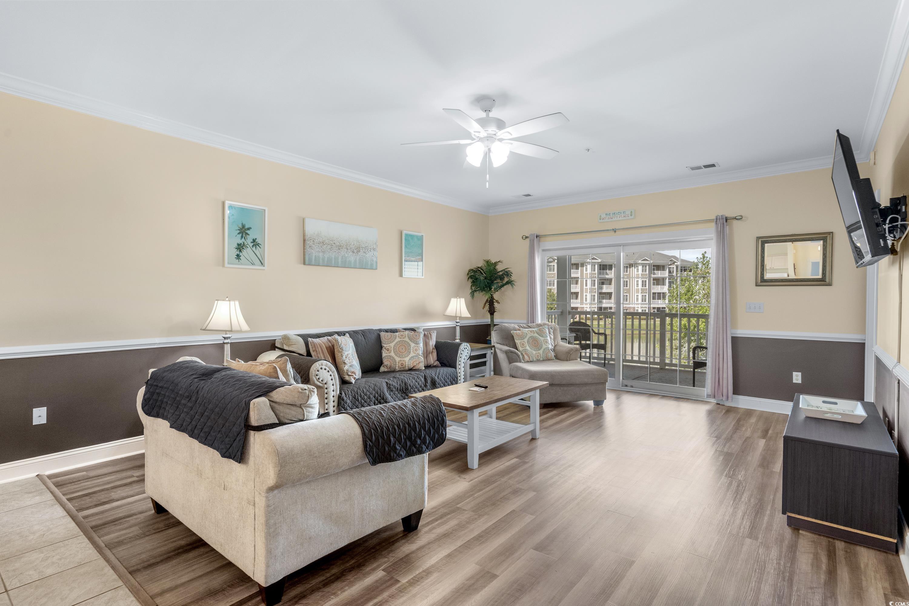 Furnished living room with a sectional sofa and balcony doors overlooking apartment buildings.