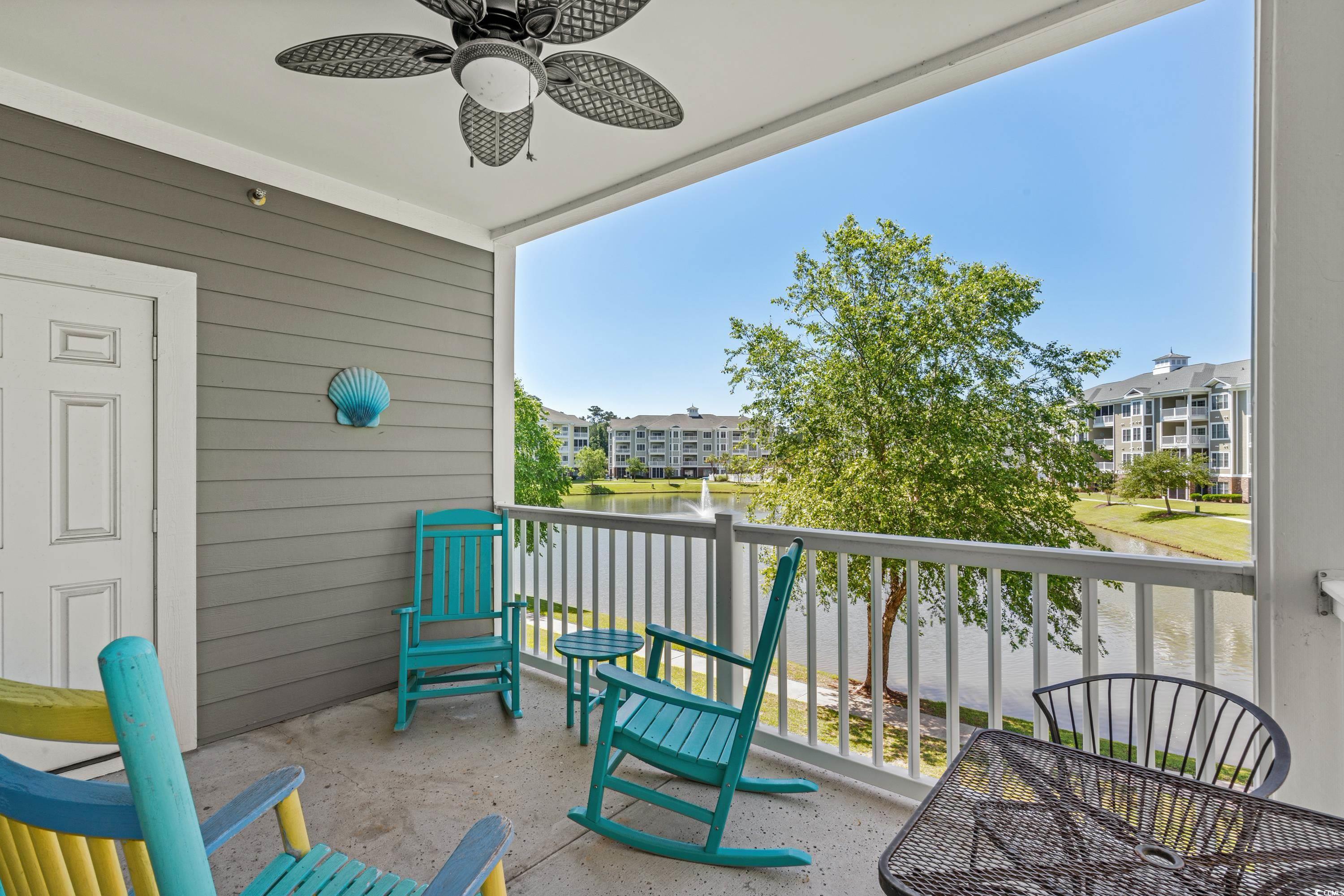 Apartment balcony with turquoise rocking chairs overlooking a pond and fountain.