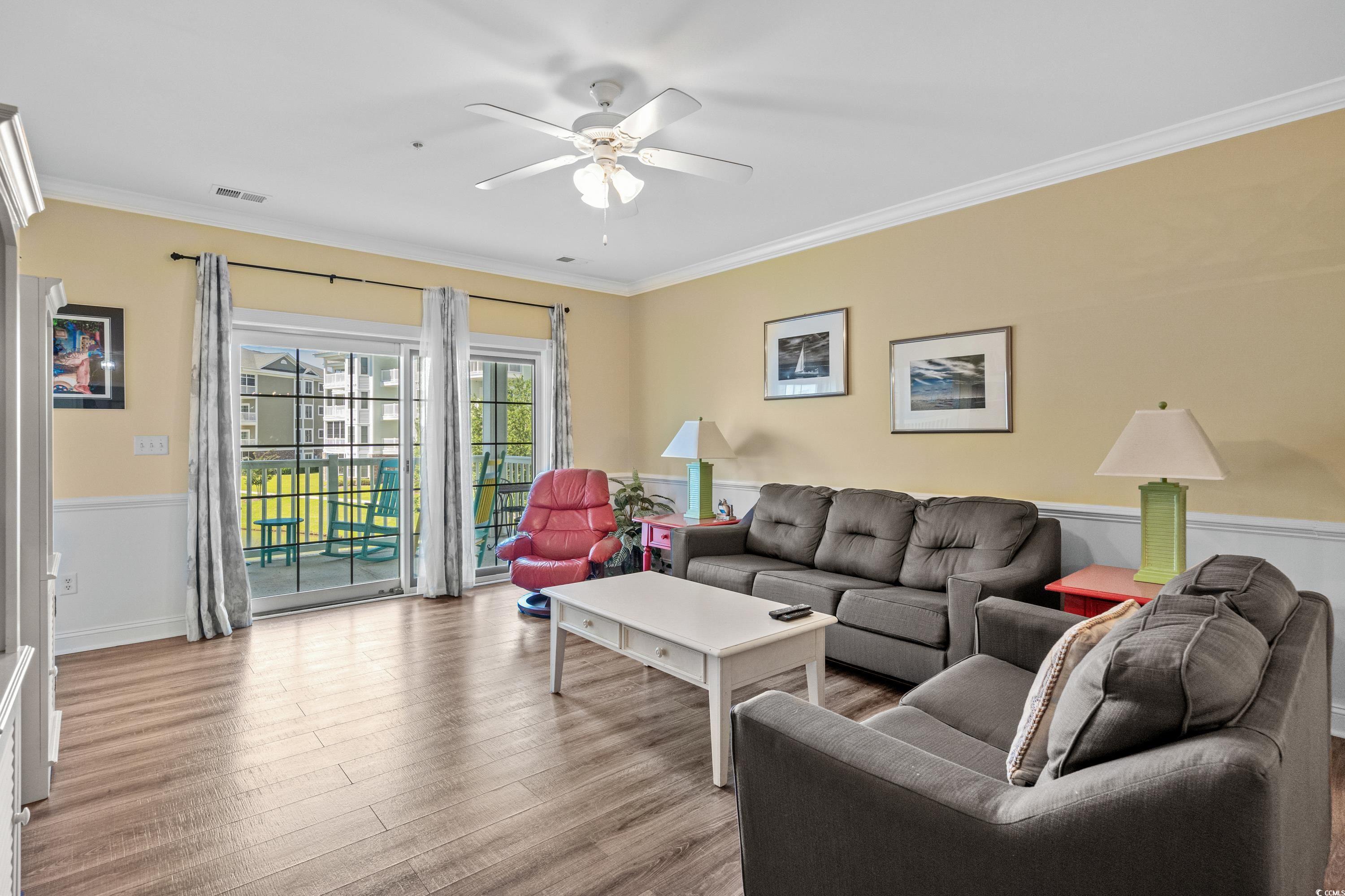 Furnished living room with gray sofas, red recliner, and sliding doors to a balcony.