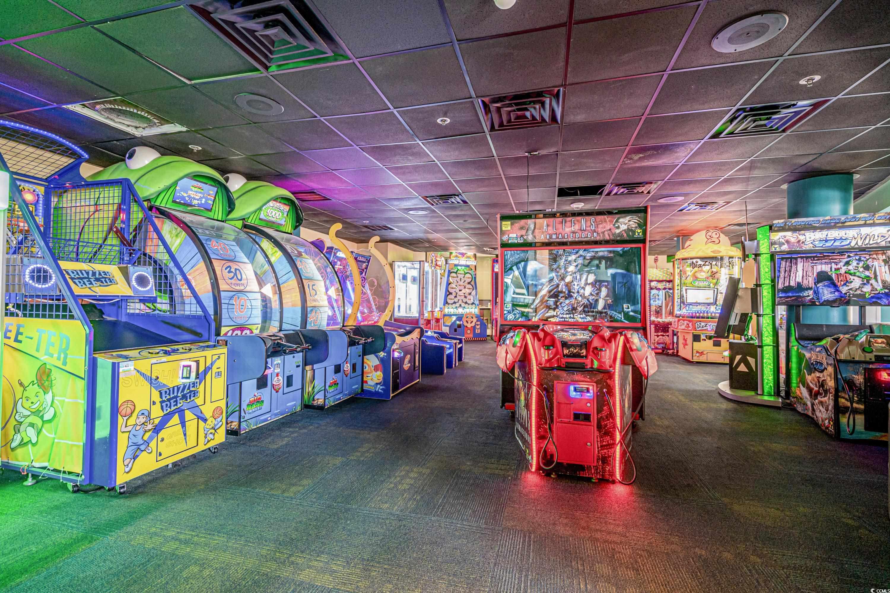 Indoor arcade with colorful game cabinets, including a red Aliens Armageddon game.