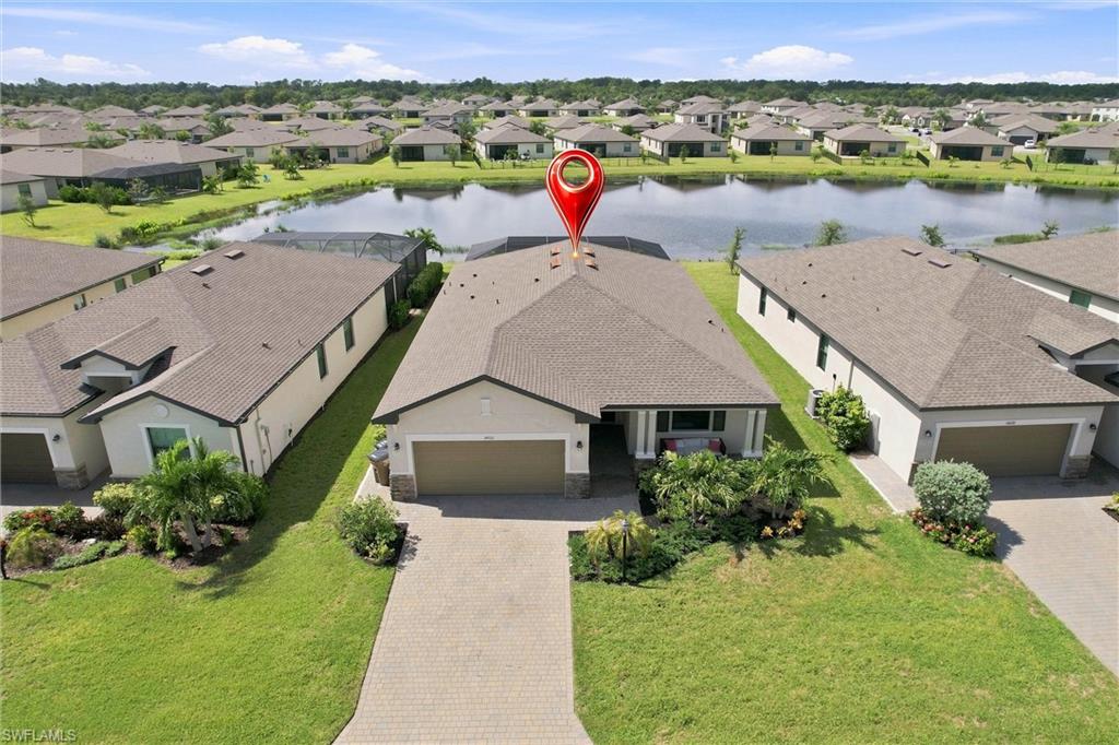 Aerial view of a lakefront home with a red location pin above its roof.
