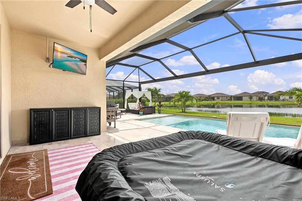 Screened lanai with a pool, inflatable hot tub, and lake view.
