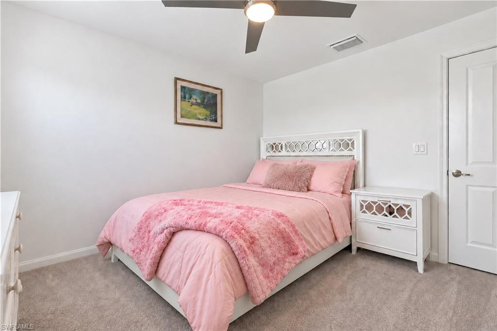 Bedroom with a white bed dressed in pink bedding and a textured pink throw.