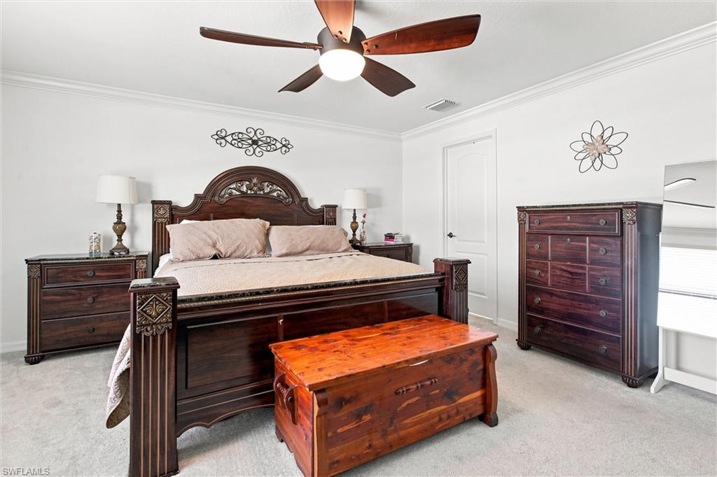 Bedroom with a carved dark wood bed, matching dressers, and a wooden chest at the foot of the bed.