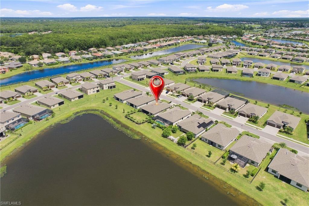 Aerial neighborhood view with a red pin marking a home beside ponds and canals.