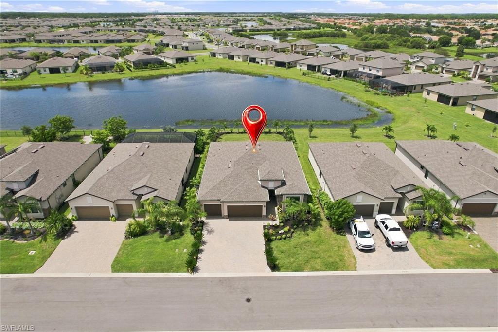 Aerial view of a single-story home by a neighborhood lake, marked with a red pin.