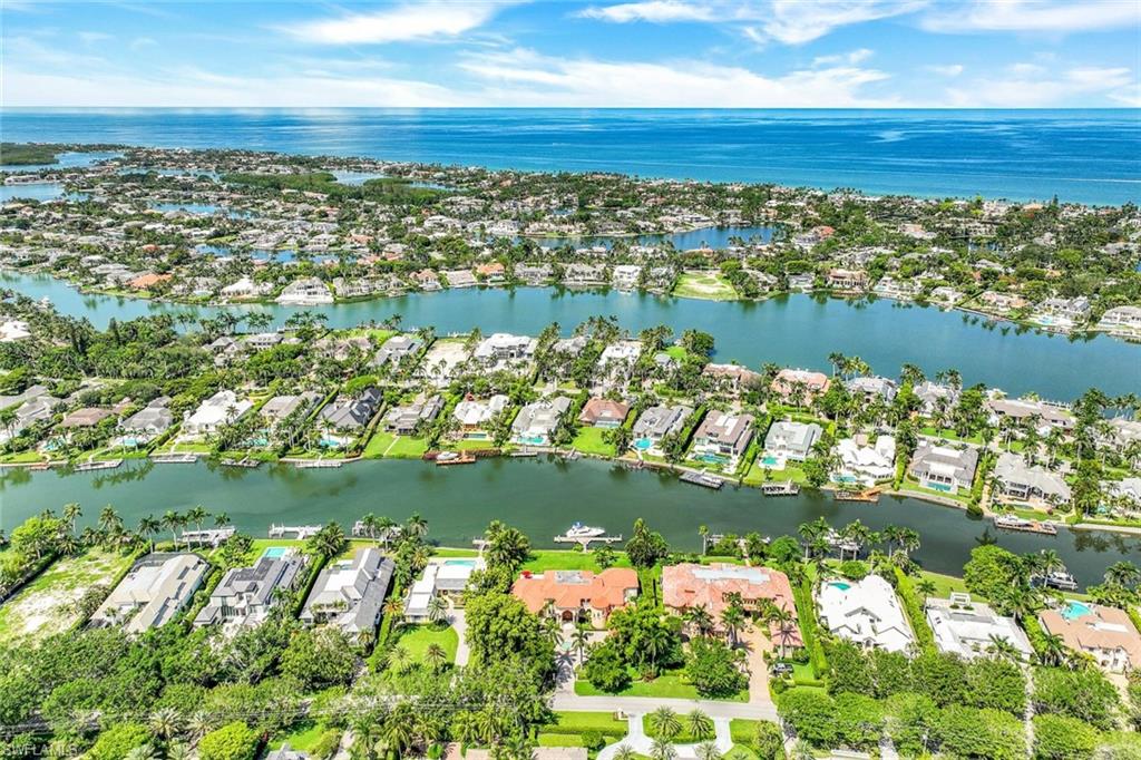 Aerial view of Naples waterfront homes, canals, and the Gulf of Mexico.