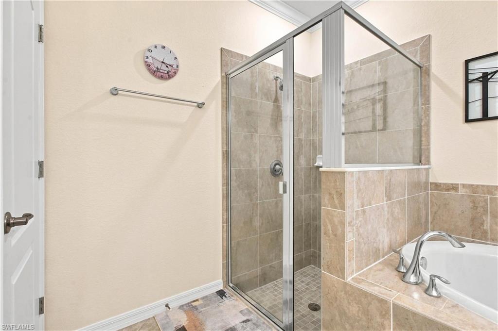 Bathroom with a glass-enclosed tiled shower beside a built-in soaking tub.
