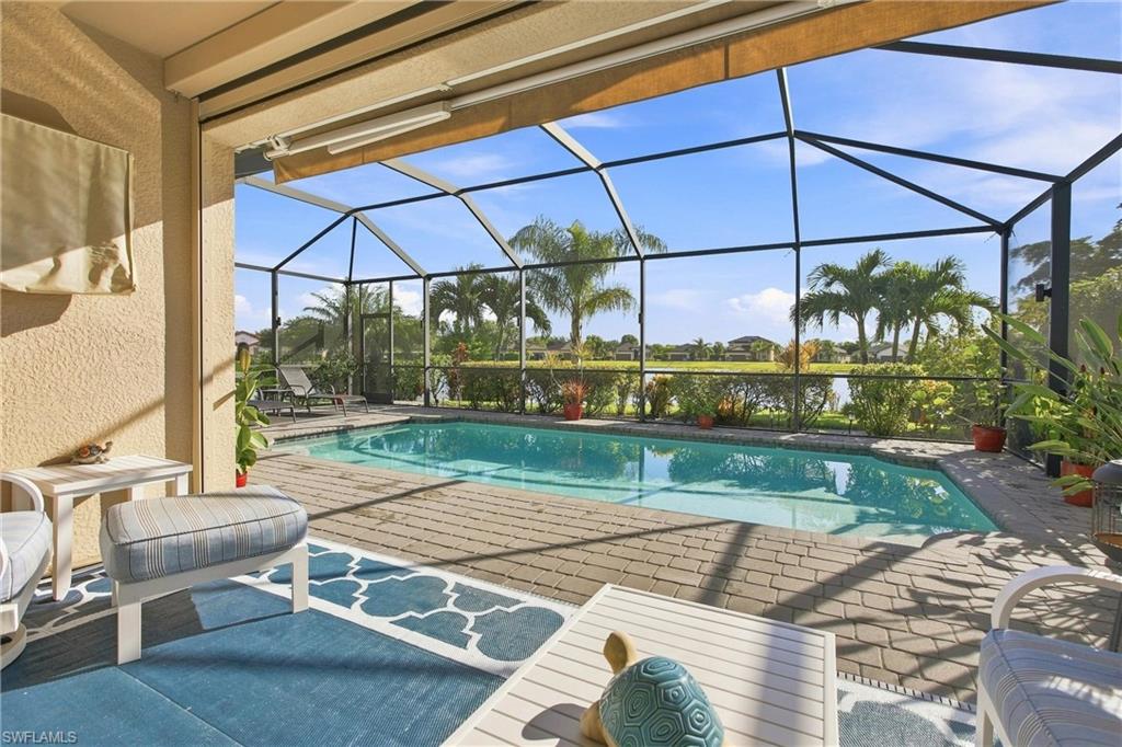 Screened pool lanai with outdoor seating and a view of the lake.