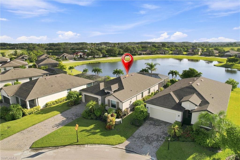 Aerial view of a home beside a neighborhood lake, marked with a red location pin.