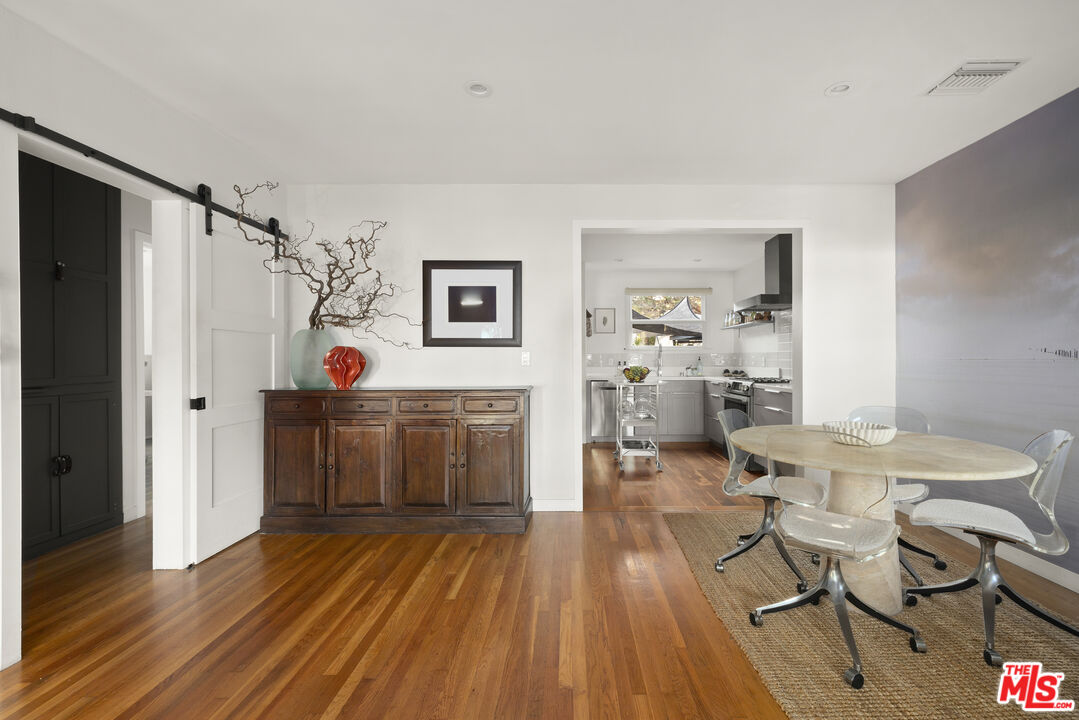 Dining room with a round table and rolling chairs beside a doorway to the kitchen.