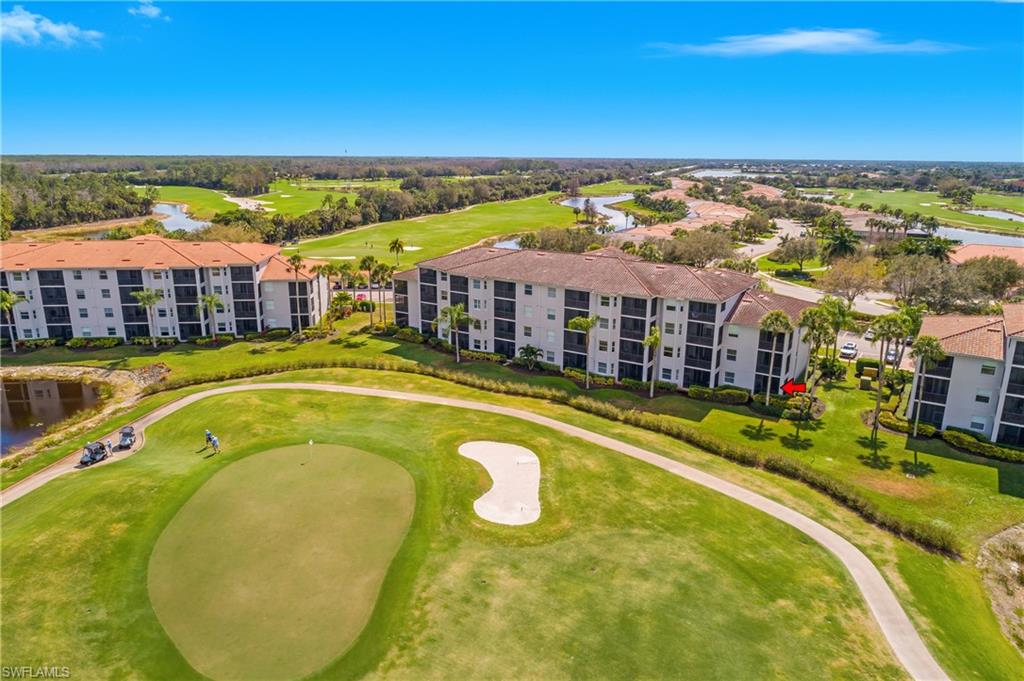 Aerial view of a condo beside the golf course, with a red arrow marking a unit.
